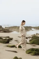 Pantalón de lino color beige, de calce amplio y tiro alto. Presenta abertura lateral en el ruedo.