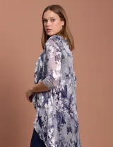 Conjunto de vestido azul marino con chaqueta estampada con motivos florales en tonos plateados y azules.