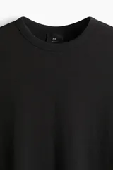 Remera negra de algodón pesado con textura waffle, cuello redondo ribeteado acanalado y corte estándar.