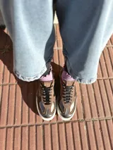 Zapatillas deportivas de cuero color peltre, con suela blanca y diseño moderno.