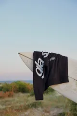 Sudadera con capucha negra, de manga larga, con estampado blanco en la espalda que dice "glassy waves" y otros símbolos.