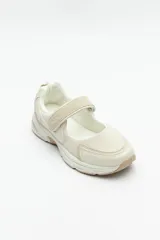 Zapatilla negra con tira ajustable y velcro.