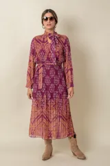 Vestido plisado de gasa estampada, con lazo en la cintura y en el cuello, de corte largo.