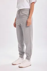 Pantalón deportivo jogger gris claro con cintura elástica ajustable con cordón y tobillos ajustados.