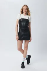 Vestido de símil cuero negro sin mangas con breteles ajustables y cierre metálico en la espalda.