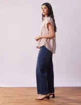 Camisa color beige con estampado de hojas marrones, de manga corta, con cuello a la base con solapa y escote en V.