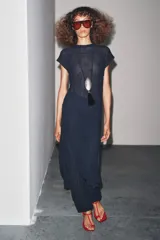 Vestido midi azul marino semitransparente de punto fino con efecto arrugado, cuello redondo, manga corta y aberturas laterales en el bajo. Cierre en la espalda con lazo.