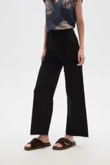 Pantalón de jean color beige, de corte flare y tiro alto, con terminación desflecada.