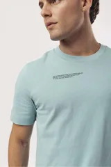 Remera de algodón color naranja claro con cuello redondo y manga corta. Presenta un pequeño estampado gráfico de temática playera en el pecho izquierdo.