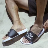 Chanclas de hombre marca Umbro, modelo Locker Room. Presentan una banda superior de color negro con el logo de la marca en blanco y una suela de goma blanca anatómica diseñada para mayor confort.