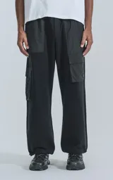 Pantalón jogger negro con múltiples bolsillos, botamanga regulable y cintura elastizada. Confeccionado en algodón combinado con microfibra y calce relaxed fit.
