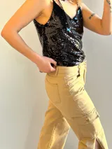 Musculosa negra con lentejuelas y tirantes finos.