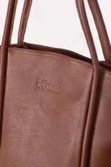 Bolso tote de cuero color marrón con doble asa de mano.