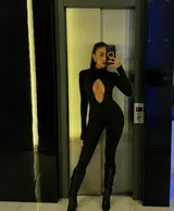 Catsuit negro de calce ajustado, con cuello alto, mangas largas y abertura en forma de gota en el pecho.