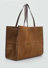 Bolso tipo shopper color bordó, confeccionado en cuero vacuno, con cierre de botón magnético, asa de hombro y bolsillo interior.