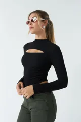 Top blanco de manga larga con cuello alto y abertura en el pecho. Corte ajustado y tejido elastizado.