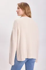 Sweater color crudo de punto inglés con cuello redondo y mangas largas.