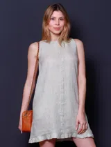 Vestido corto amarillo de lino, sin mangas y con volados en el ruedo.