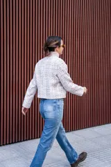 Chaqueta corta tipo Chanel de tweed color rosa, con botones fantasía y cuello redondo.