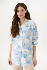 Camisa blanca con estampado de hojas de gingko color azul, de corte recto y manga larga.