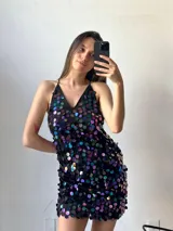 Minivestido negro con lentejuelas grandes de colores tornasolados, escote en V y breteles finos.