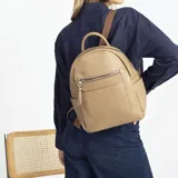 Mochila negra de símil cuero con bolsillo frontal con cierre. En su interior tiene dos bolsillos con cierre y uno abierto con división. Tiene asa de mano y correas regulables.