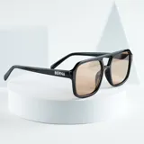 Lentes de sol con montura cuadrada negra y lentes color caramelo con protección UV400.