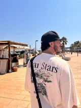 Remera celeste con estampa de paisaje costero y texto "Ittai Stars" y nombres de ciudades.