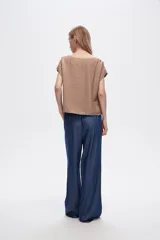 Pantalón azul de lyocell, de corte ancho y tiro alto, con cintura elastizada y bolsillos laterales.