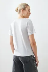 Remera color beige con lurex, de manga corta y corte recto.