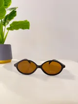 Lentes de sol con marco de acetato negro y lentes color ámbar.