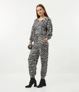 Blusa de viscosa con estampado animal print en blanco y negro, escote en V, mangas largas abullonadas con puños ajustados y dobladillo mullet.