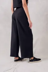 Pantalón de tiro alto color negro, de corte amplio y tejido suave, ideal para el uso diario.