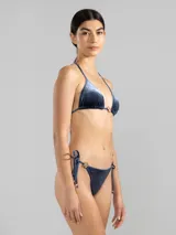 Top de bikini triángulo azul de terciopelo con textura a rayas finas, tiras ajustables en cuello y espalda, y charm metálico color oro rosado en el centro del escote.