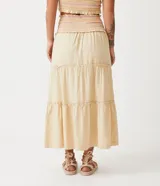 Conjunto de top corto con breteles finos y pollera midi de algodón color crema con cintura elastizada y volados en el ruedo.
