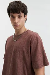 Remera de manga corta color crema con estampado abstracto en blanco, de corte recto y cuello redondo.