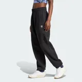 Pantalón Adidas Essentials negro de felpa francesa, corte holgado, cintura elástica con cordón ajustable y logo bordado en blanco.