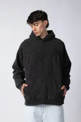 Buzo canguro marrón con capucha, confeccionado en frisa gruesa de algodón con recortes y calce oversize.