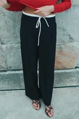 Pantalón ancho gris con textura de espiga, tiro alto, doble cintura elástica ajustable con cordón, pinzas frontales, bolsillos delanteros y falso bolsillo de vivo en la espalda.