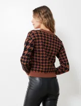 Cárdigan tejido marrón con estampado pata de gallo en negro, escote en V y cierre frontal con botones.