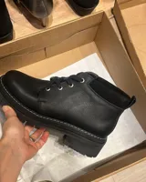 Borcego marrón de cuero con cordones, caña baja y suela track.