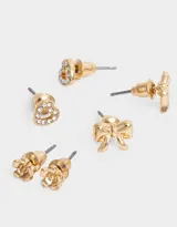 Set de tres pares de aros pasantes dorados: un par con forma de corazón con strass, un par con forma de flor y un par con forma de moño.