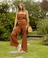 Zapatillas deportivas color beige con detalles dorados, cordones al tono y suela blanca.