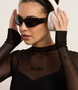 Blusa deportiva de tule negro, con cuello alto, mangas largas y estampa frontal con la palabra 'muse'.