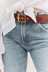 Cinturón marrón de cuero con hebilla cuadrada dorada y ojales metálicos.