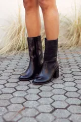 Botas de cuero negro con caña media, taco cuadrado y puntera redondeada.