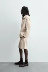 Sobrecamisa color beige de algodón con estructura canvas, corte relaxed fit, cuello solapa, manga larga con puño abotonado, bolsillos de plastrón frontales y cierre frontal con botones.