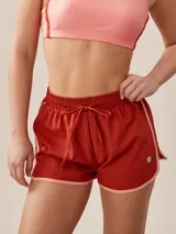 Short deportivo color ladrillo con cintura elastizada y cordón ajustable. Presenta ribete color salmón en ruedo y laterales.
