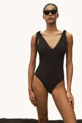 Traje de baño negro de una pieza, con escote en V, breteles con moños y copas con relleno extraíble.