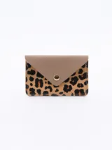 Billetera pequeña con solapa, con estampado animal print de leopardo y cierre con broche metálico dorado.